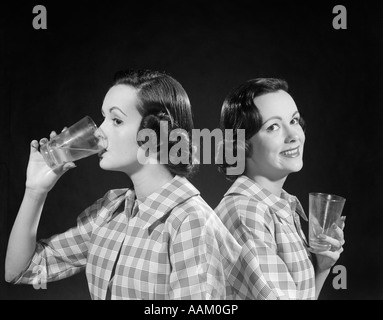 Années 1950 Années 1960 DOUBLE EXPOSITION D'UNE FEMME EN Chemise à carreaux de verre et BOIRE D'UNE SUITE SMILING AT CAMERA Banque D'Images