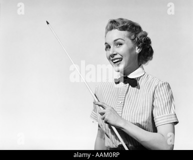 1950 PORTRAIT WOMAN SMILING HOLDING POINTEUR LOOKING AT CAMERA Banque D'Images