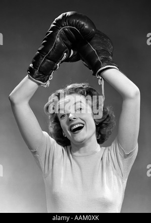 1950 Portrait de femme portant des gants de boxe en remportant posent bras levés PASSAGE LOOKING AT CAMERA Banque D'Images