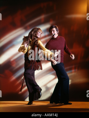 1960 L'HOMME ET DE LA FEMME DANS LA DANSE DISCO CLUB LE PORT DE PANTALON ET VESTE à franges FAD FUN COUPLE NOSTALGIE Banque D'Images