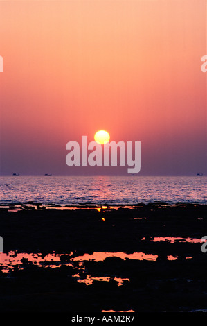 Coucher de soleil sur les récifs coralliens avec les bateaux d'Anchois à l'horizon, Ko Lanta, Thaïlande Banque D'Images