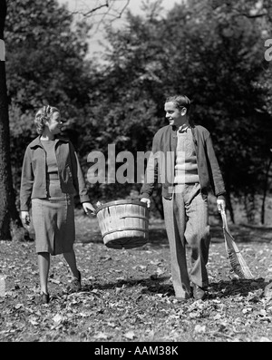 Années 1930 Années 1940 TEEN COUPLE CARRYING BASKET LES FEUILLES D'AUTOMNE Banque D'Images