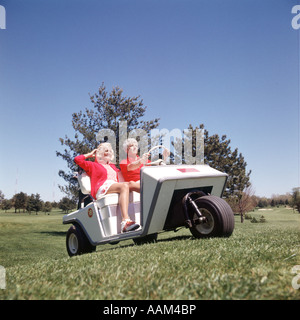 Années 1970 EN COUPLE HOMME CONDUISANT DE CHARIOT DE GOLF CHARIOT DE GOLF Banque D'Images