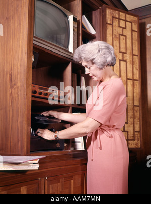 Femme rétro années 70, 1970 DOSSIERS DE JEU DE METTRE SUR RECORD PLAYER Banque D'Images