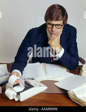 L'HOMME D'AFFAIRES DE BUREAU CALCULATRICE CALCULATRICE DE TRAVAIL COMPTABLE 1970 perplexe 1970 RETRO Banque D'Images