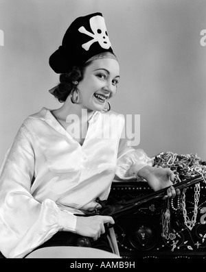 1940 WOMAN WEARING PIRATE COSTUME HOLDING RIFLE DANS LAP S'APPUYANT SUR L'INTÉRIEUR DE FAISCEAUX DE TRÉSOR Banque D'Images
