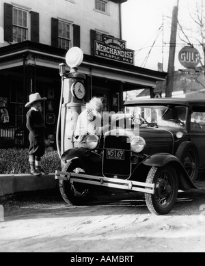 Grand-père âgé de la MISE À NIVEAU DE FORD VOITURE À L'AVANT DU MAGASIN GÉNÉRAL DE PENNSYLVANIE Avec petit-fils regardant des années 1930 Banque D'Images