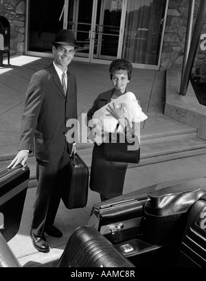 1960 COUPLE TAKING NOUVEAU BÉBÉ ACCUEIL DE L'HÔPITAL PÈRE HOLDING voiture décapotable PORTE OUVERTE POUR LA MÈRE Banque D'Images