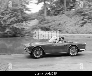 1960 COUPLE roulant en voiture sport décapotable Banque D'Images