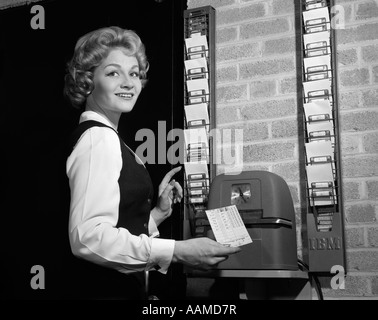 1950 WOMAN IN OFFICE AVEC TIMECARD ET L'horloge de pointage Banque D'Images