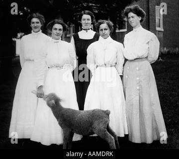 Années 1900 DÉBUT DU SIÈCLE GROUPE DE CINQ FEMMES un biberon de lait HOLDING LAMB Banque D'Images