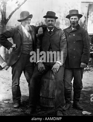 1890 DÉBUT DU SIÈCLE GROUPE DE TROIS HOMMES AVEC barbe ou moustache porter un chapeau l'un assis sur le fût Banque D'Images