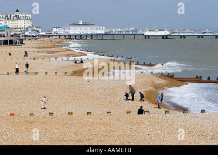 La plage d'Eastbourne comme vu de la jetée avec les hommes à jeter des pierres dans la mer Banque D'Images