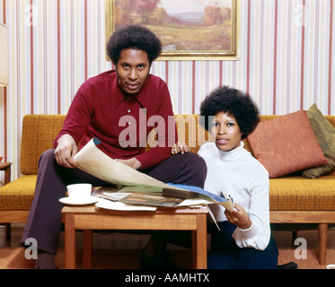 1970 Africains-Américains HOMME FEMME COUPLE MARI ÉPOUSE À LA NOUVELLE MAISON MODÈLE TABLE BASSE PORTRAIT RÉTRO AFRO Banque D'Images