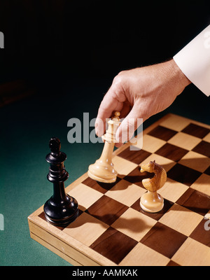 1960 1960 HOMMES MANS HAND HOLDING CHESS PIECE DÉPLACER DÉMÉNAGEMENT CHECKMATE CHECK MATE RÉTRO jeu jeux de stratégie Banque D'Images
