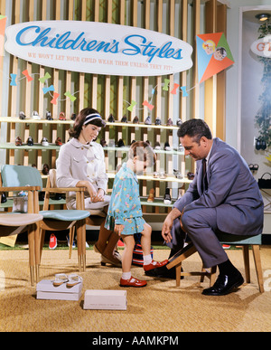 Mère regardant bon vendeur de chaussures LE FILLE EN SERVICE DE LA SECTION DE DEPARTMENT STORE Banque D'Images