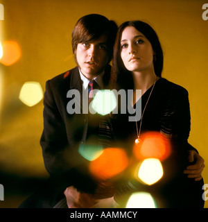 1970 JEUNE COUPLE HOMME FEMME TÊTE À TÊTE DE vêtus de noir caméra REGARDE STYLE MOD EXPRESSION GRAVES FEUX DE FLOU Banque D'Images