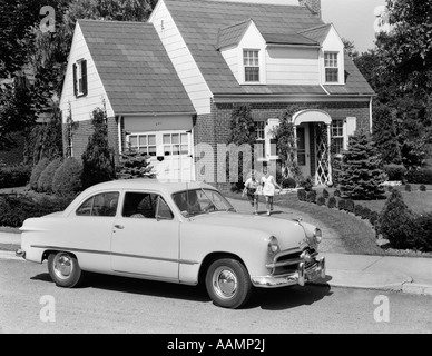 Années 1940 Années 1950 SON & DAUGHTER FONCTIONNANT À PARTIR DE LA CHAMBRE VERS L'AUTOMOBILE FORD 1948 Banque D'Images