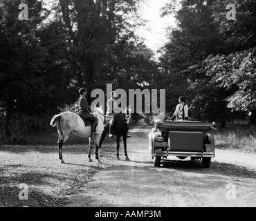 Années 1920 Années 1930 SUR LES CHEVAUX COUPLE FEMME RENCONTRE SUR ROAD IN CONVERTIBLE TOURING CAR Banque D'Images