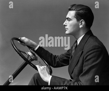 Années 1930 Années 1940 HOMME PORTANT costume et cravate TENANT LE VOLANT DE L'AUTOMOBILE Banque D'Images