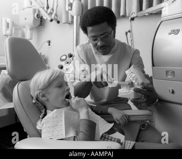 1970 AFRICAN AMERICAN DENTIST SHOWING PETITE FILLE COMMENT SE BROSSER LES DENTS sur grand modèle Banque D'Images