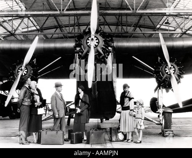 Années 1920 Années 1930 GROUPE DE PASSAGERS EN ATTENTE DEVANT FORD TRI-AVION À MOTEUR Banque D'Images