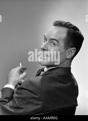 1950 3 4 Profil L'HOMME À LA CIGARETTE par-dessus son épaule en souriant LA MAIN Banque D'Images