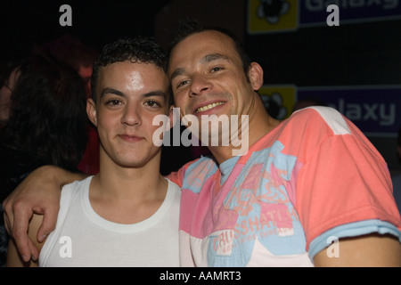 Jeune homme couple gay afficher d'affection en public dans une discothèque Banque D'Images
