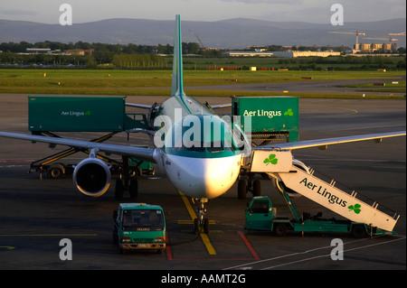 Airbus A320 d'Aer Lingus EI 211 CPG St Aodhan assis dans soleil du soir sur le tarmac avec étapes et Aer lingus van en cours de chargement Banque D'Images