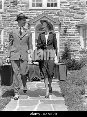 Années 1930 Années 1940 SMILING COUPLE QUITTER ACCUEIL TRANSPORT DES BAGAGES Banque D'Images