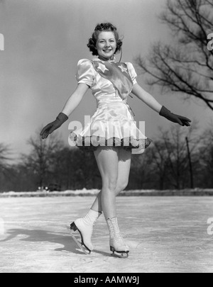 1940 SMILING WOMAN, patineuse artistique PERFORMER SUR LA GLACE PORTANT DES GANTS ET LOOKING AT CAMERA Banque D'Images