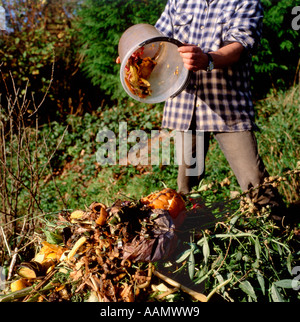 Un homme se renverser un seau de déchets végétaux de sa cuisine sur un tas de compost au Pays de Galles, UK KATHY DEWITT Banque D'Images