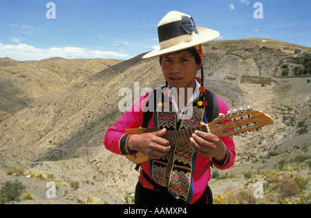 Un Indien portant des vêtements traditionnels joue le charango dans la région des Andes de la Bolivie entre Oruro et Cochabamba Banque D'Images
