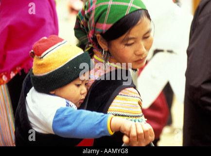 L'alimentation de l'enfant à partir de la part de mère Flower Hmong, Bac Ha, Tonkinois, Alpes du Nord Vietnam Banque D'Images