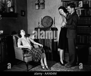 1940 YOUNG COUPLE DANCING À RADIO WOMAN SITTING IN CHAIR Banque D'Images