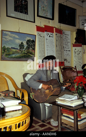 Poète bohème Duy Viet strum guitar dans sa maison/cafe/studio, Dalat, Vietnam Banque D'Images