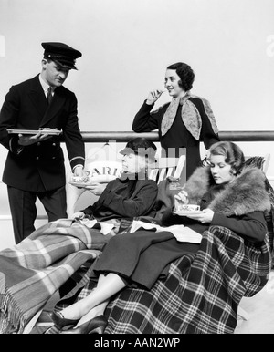 Années 1930 Années 1920 Trois femmes d'être servis le thé PAR UN STEWARD À BORD D'UN paquebot traversant l'OCÉAN ATLANTIQUE Banque D'Images