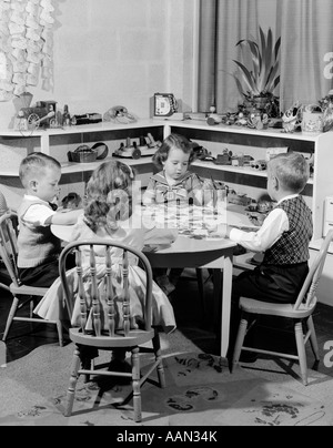 1950 4 L'âge préscolaire des enfants assis à la petite TABLE RONDE PUTTING TOGETHER Jigsaw Puzzle Banque D'Images