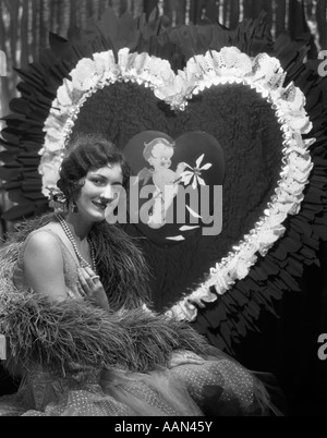 Années 1920 Années 1930 SMILING YOUNG WOMAN LOOKING AT CAMERA DOIGT CHEVEUX COLLIERS DE PERLES D'ONDE VALENTINE GÉANT Banque D'Images