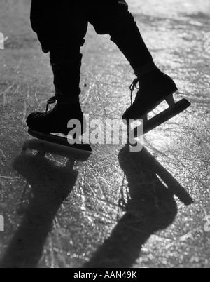 1930 SILHOUETTE FIGURE ILLUSTRÉ DE GENOUX VERS LE BAS Le port de patins à glace glace PATINAGE AU REFLET DU SOLEIL Banque D'Images