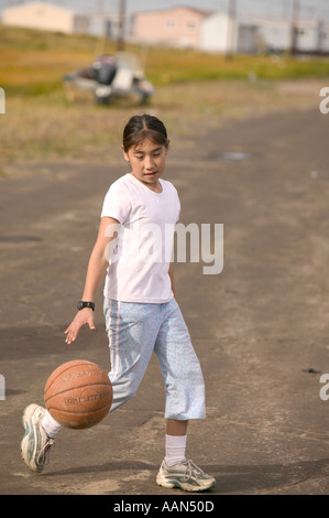 Emma Weyiouanna un esquimau enfant jouant basket ball sur l'île de shishmaref communautaire qui est menacée par le réchauffement climatique Banque D'Images