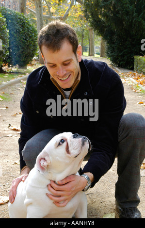 Parution modèle jeune homme jouant avec son chien, un bulldog Anglais Nano Calvo VWPics com Banque D'Images