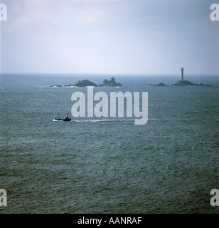 Petit BATEAU DE PÊCHE ET LE PHARE DE DRAKKARS OFF LAND'S END CORNWALL UK Banque D'Images