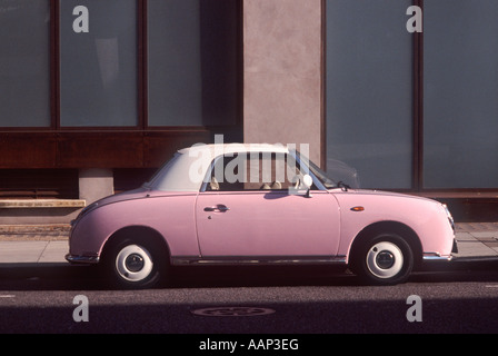 Nissan Figaro rose de cette version : 2 toile de toit porte soleil mode rétro voiture (1991) stationné sur une rue de Covent Garden, Londres Banque D'Images