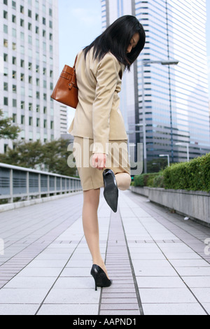 Un jeune businesswoman contrôle talon Banque D'Images