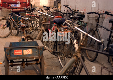 Location vélo à tours les hutongs ruelles et maisons traditionnelles avec salle de cours et de petites rues Beijing Chine Banque D'Images