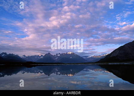 Une chaîne de montagnes et nuages reflétée dans le miroir lisse de l'eau de Glacier Bay en Alaska Banque D'Images