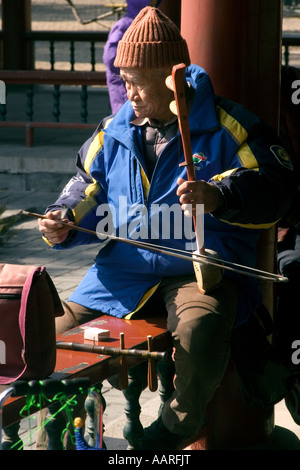 Vieil homme jouant de l'erhu, un instrument traditionnel chinois ancien à proximité du Temple du Ciel, Beijing Chine Banque D'Images