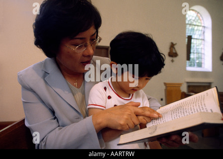 Mère coréenne lisant la Bible à l'enfant coréen dans l'église Banque D'Images