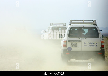 Off road 4x4 touristiques jeter vers le haut des nuages de poussières de la conduite dans le désert en Tunisie dans un convoi de toyota landcruisers Banque D'Images